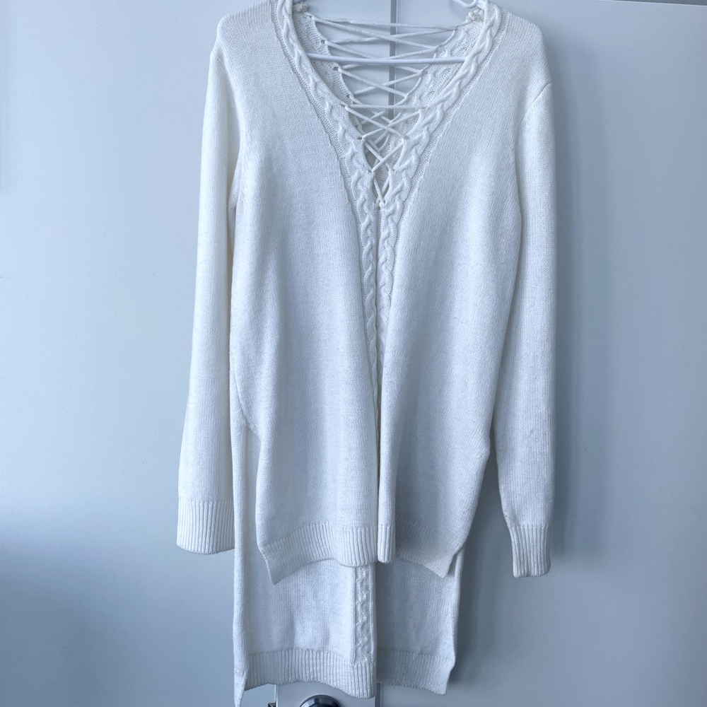 Long white sweater with details on the front and back.